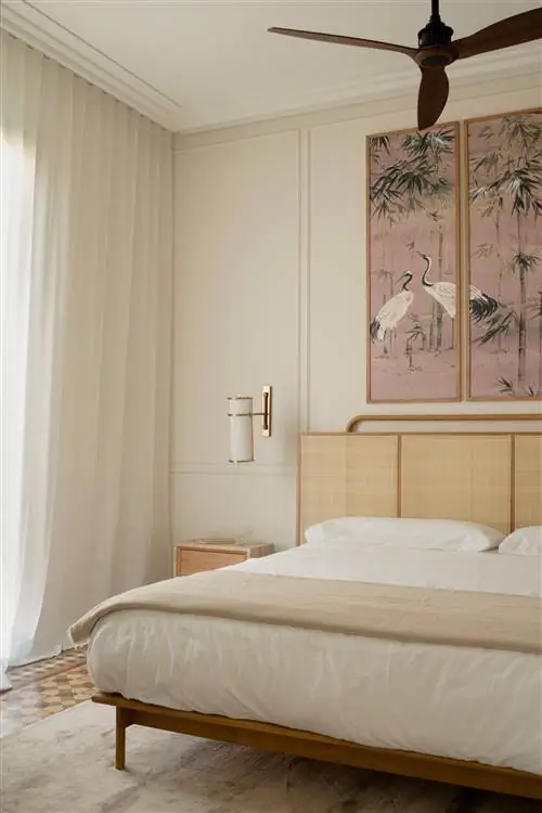 Большой триптих со сценами в азиатском стиле управляет кроватью в спальне вместе с двумя маленькими деревянными столиками…