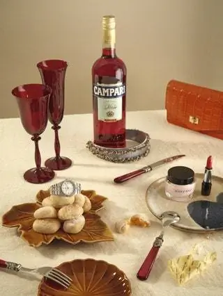 На белье Tramuntana by Gancedo бутылка Campari с повязкой на голову Tiber и кожаный мешочек, оба от помады Uterqüe…