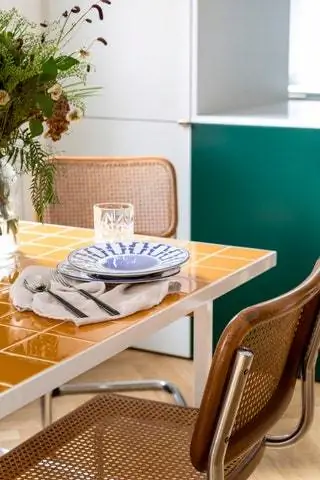 На столе в гостиной столовые приборы и льняные салфетки от Zara Home, тарелки от La Oficial Cermica и букет цветов с…