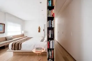 Оригинальный книжный шкаф отделяет коридор от главной спальни