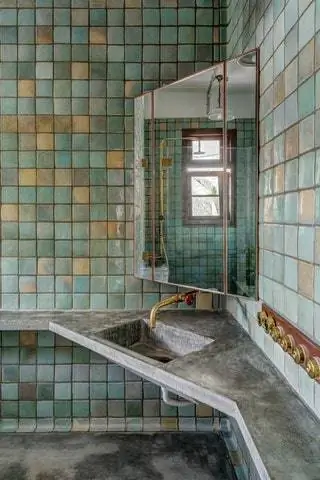 В ванной плитка ручной работы, латунные смесители и бетонная столешница