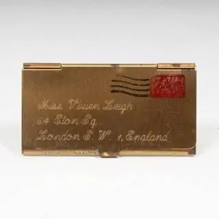 Небольшая коробочка для держателя марок, изготовленная в Англии в 1960 году. Она изготовлена из позолоченного металла, на ней адрес дома…